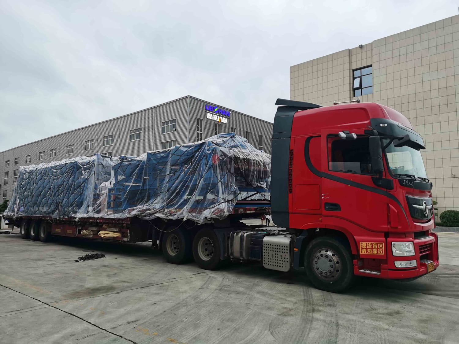 Camion cu semiremorcă platformă transportând marfă ambalată